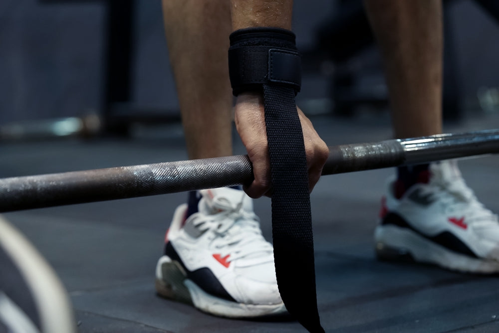 Frau benutzt Zughilfen im Fitnessstudio