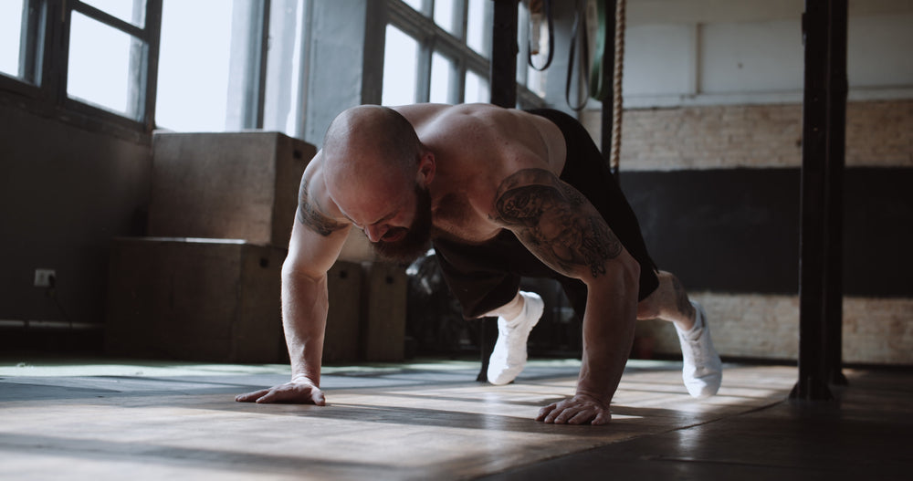 Mann macht Burpees im Fitnessstudio