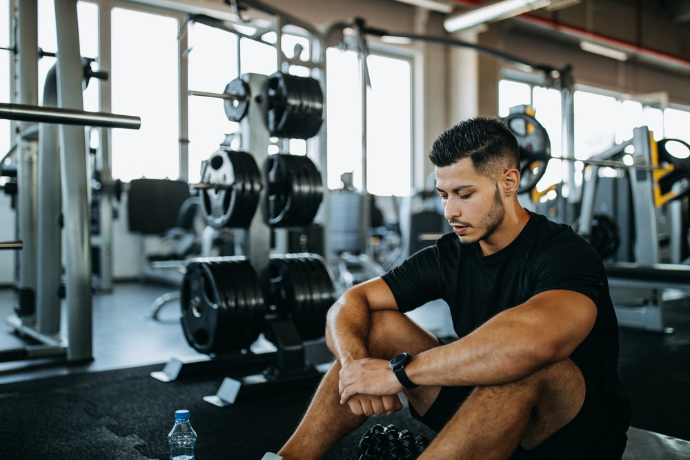 Mann macht Sitzpause im Fitnessstudio