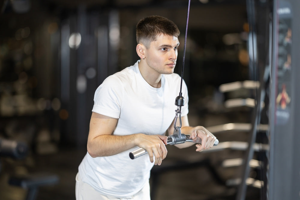 Mann macht Trizeps drücken im Fitnessstudio