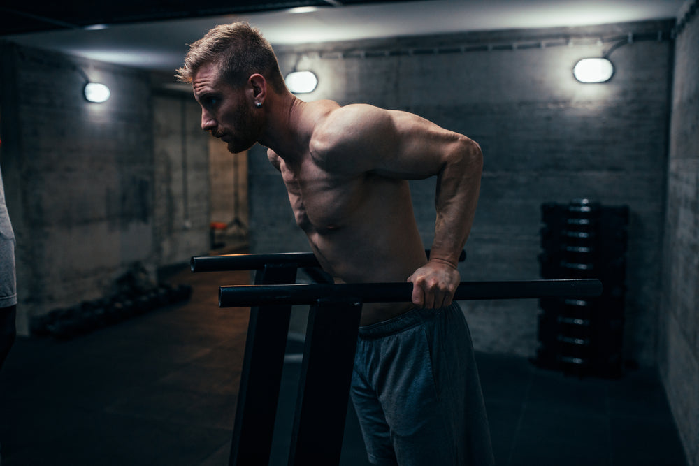 Mann trainiert Dips im Fitnessstudio