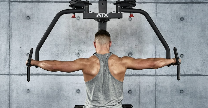 Mann trainiert Reverse Flys im Fitnessstudio