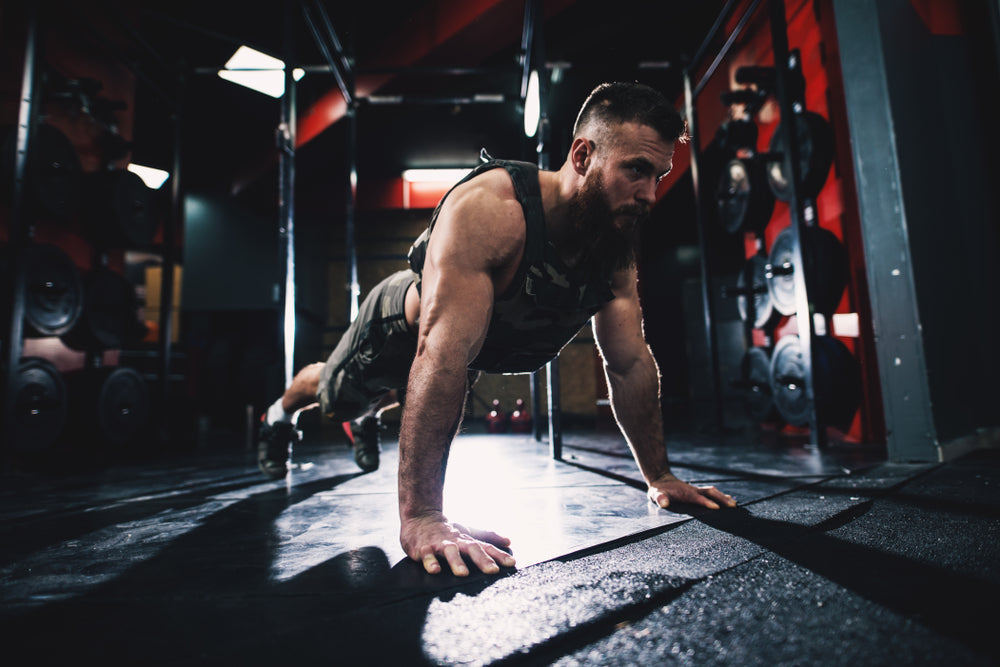 Mann trainiert mit Gewichtsweste im Fitnessstudio