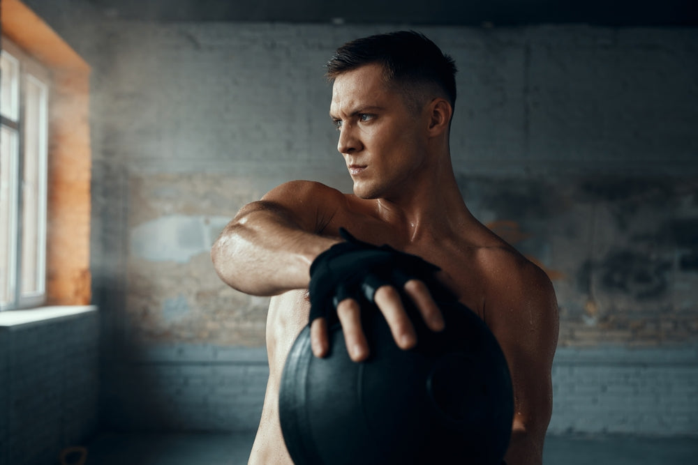Mann trainiert mit Medizinball im Fitnessstudio
