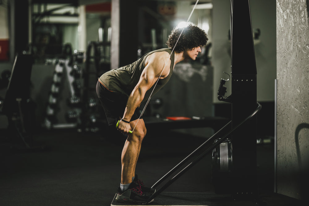 Mann trainiert mit Skitrainer im Fitnessstudio
