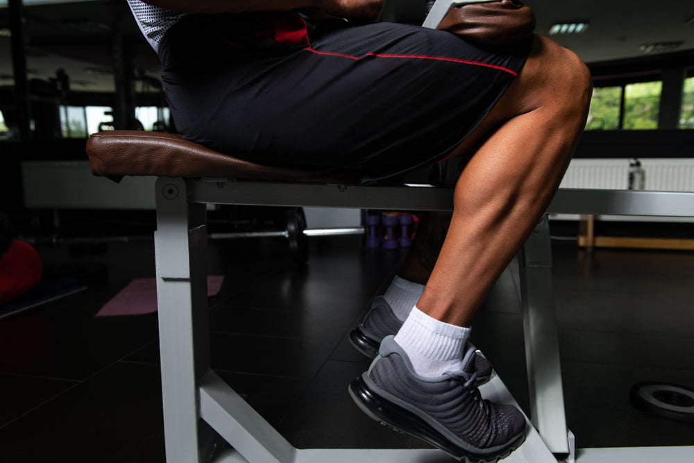 Mann trainiert an Wadenmaschine im Fitnessstudio