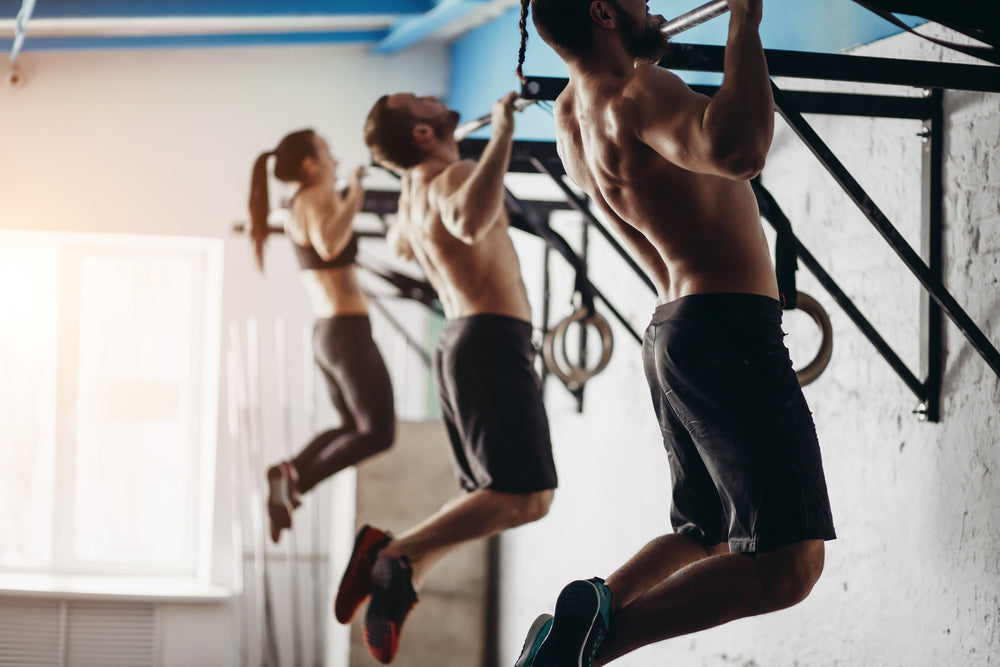 Menschen machen Klimmzüge an Klimmzugstangen im Gym